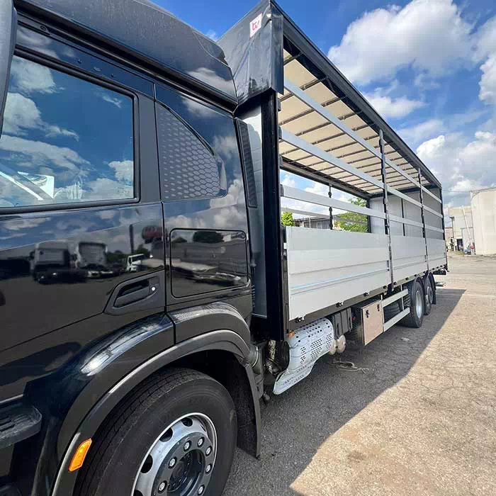 Dettaglio laterale camion nero con struttura aperta per carico merci